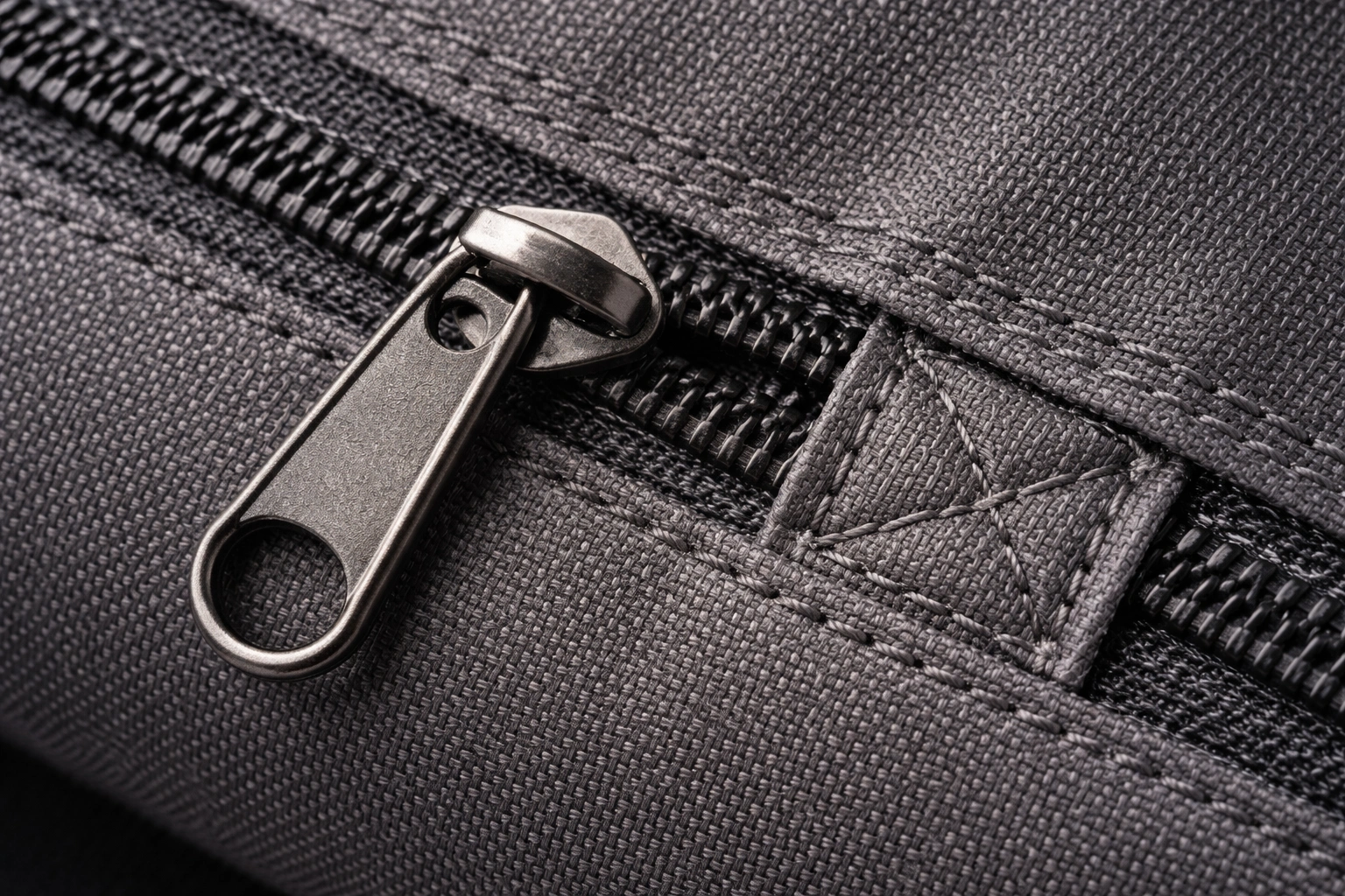 Macro close-up of durable polyester fabric texture with heavy-duty zipper and reinforced double-stitched seam detail