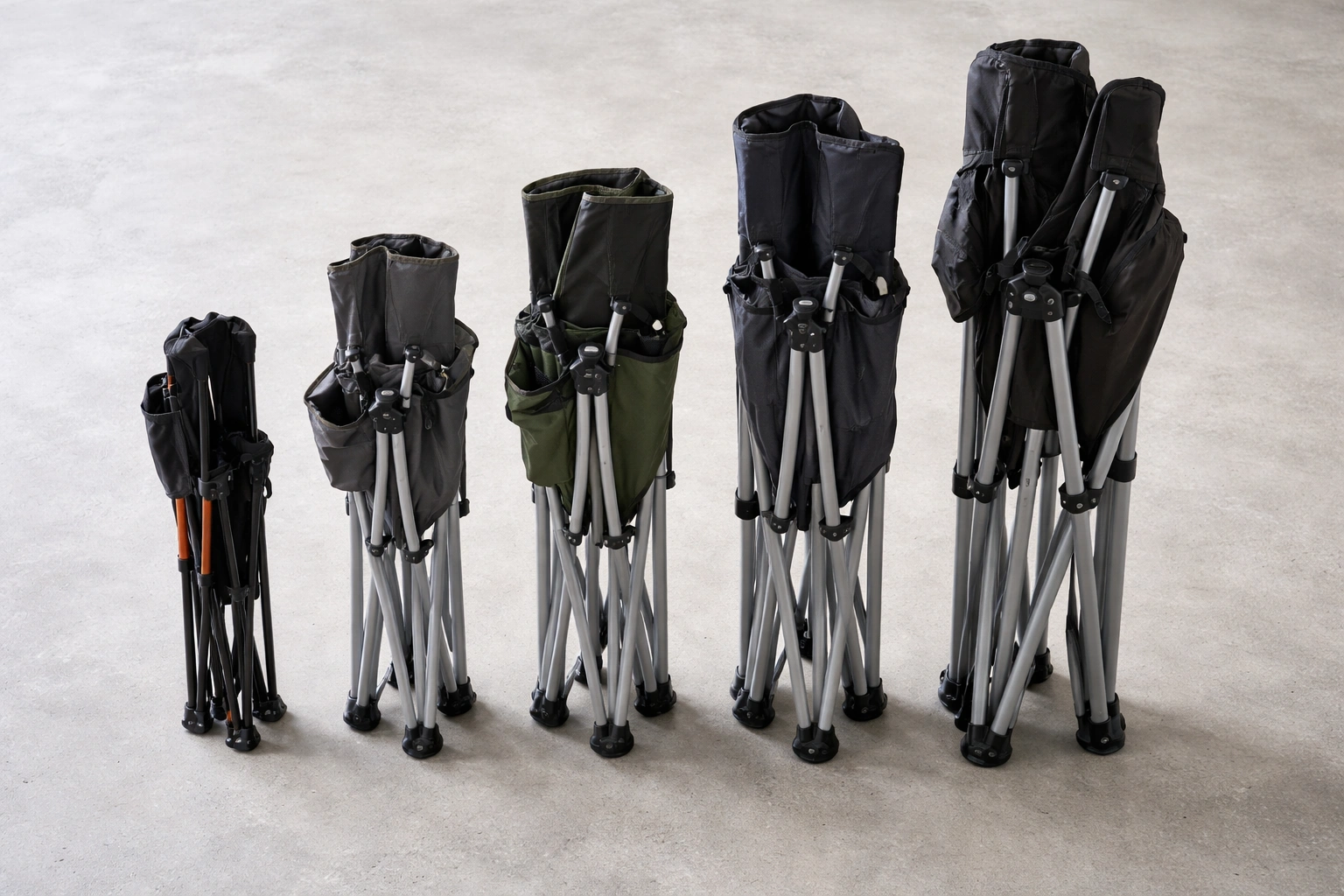 Five different folded camping chairs lined up showing size differences from tiny ultralight to large XXL chair