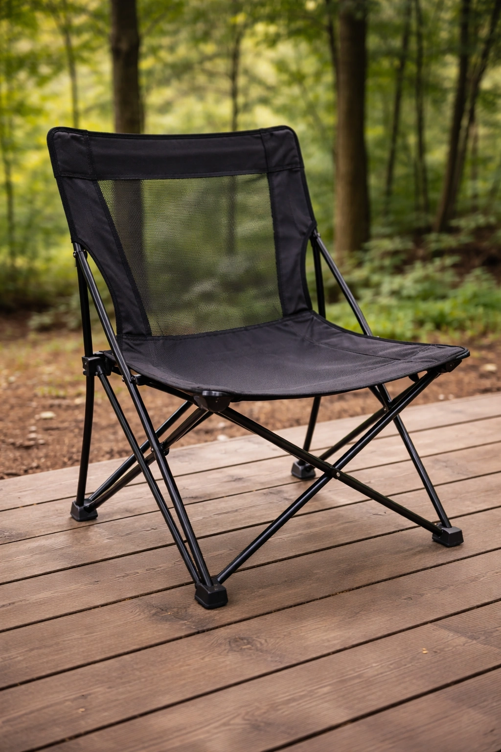 Simple lightweight camping chair with mesh back panel and basic fabric seat on wooden deck
