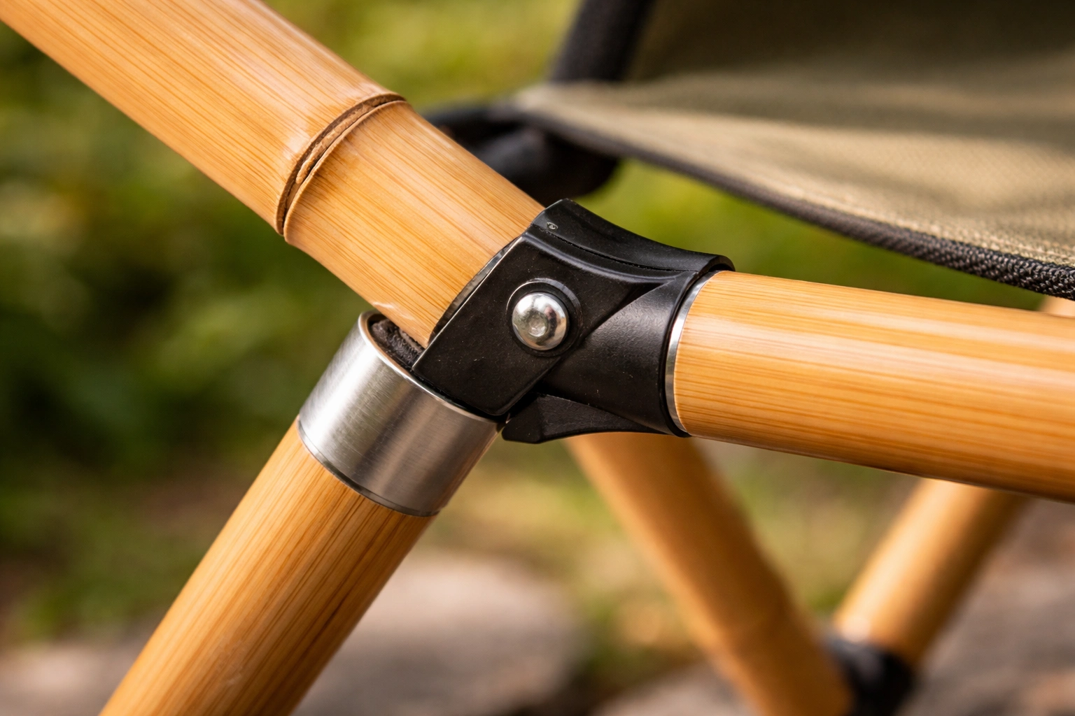 Bamboo pole frame joint of camping chair with visible grain texture and minimal metal hinge