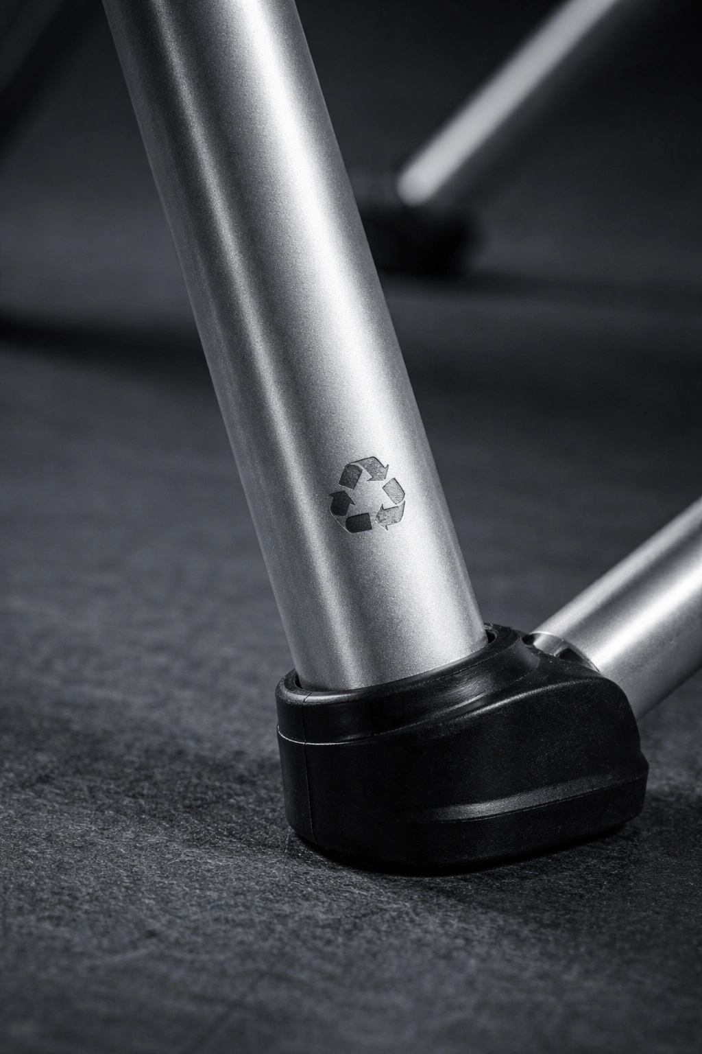 Aluminum camping chair leg tube with matte anodized finish and recycled symbol etched on dark slate