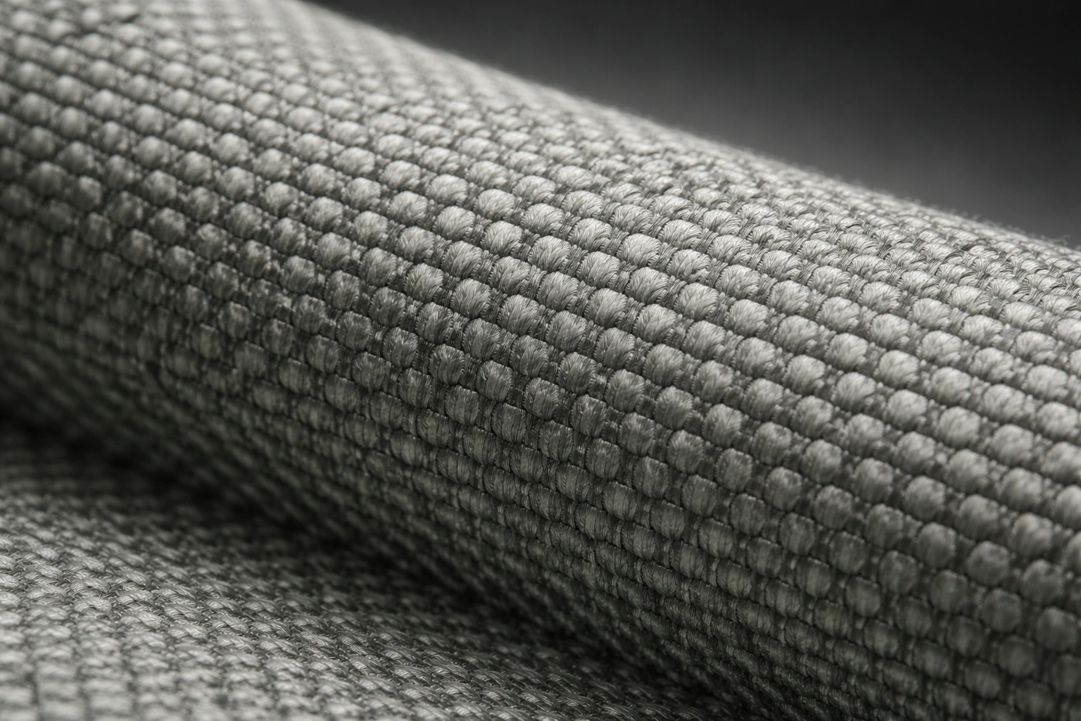 Extreme macro of woven recycled polyester fabric texture showing fine thread details in neutral grey-green
