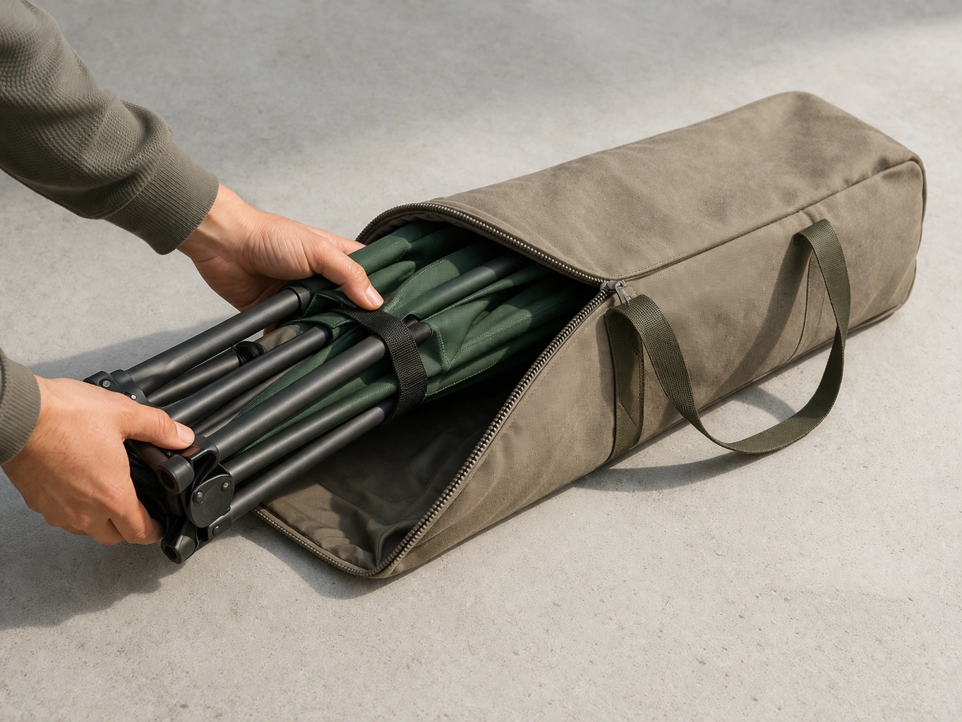 Neatly folded camping chair being placed into a padded canvas carry bag